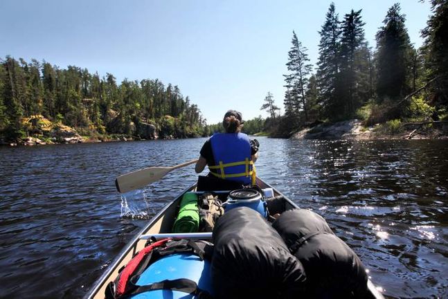 Canoeing on a calm forest-lined lake